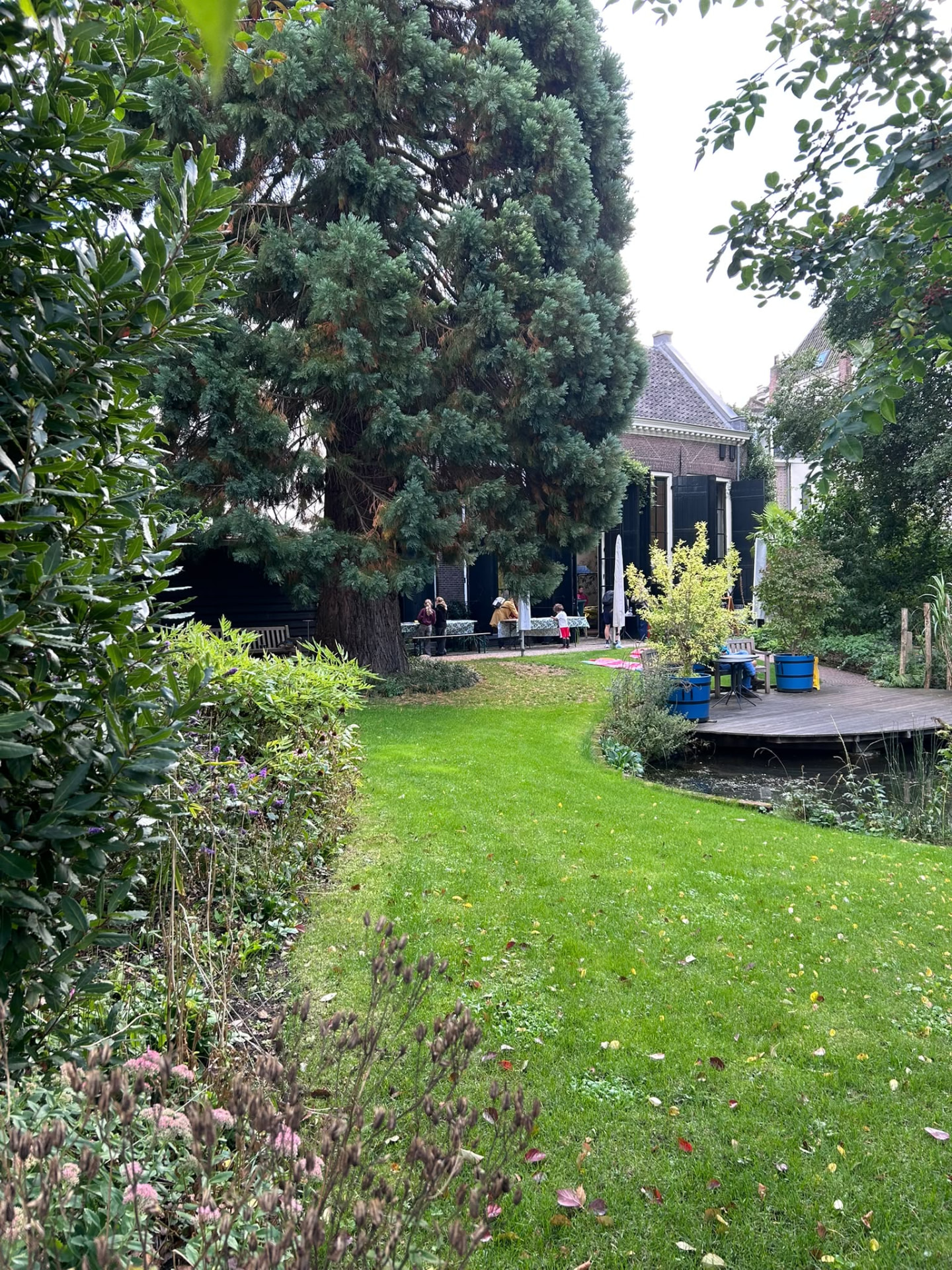 Families gathered in the green garden at the Giggly Cloud book swap.