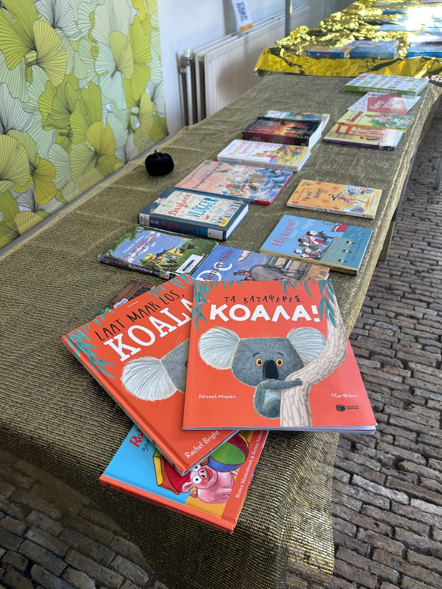 Children's books laid out on the Giggly Cloud swap table, including a bright koala cover.